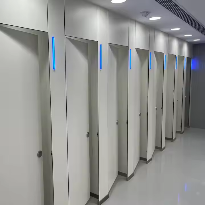 Modern HPL toilet cubicle in a commercial restroom, featuring sleek gray laminate partitions, stainless steel hardware, and a clean, hygienic design.