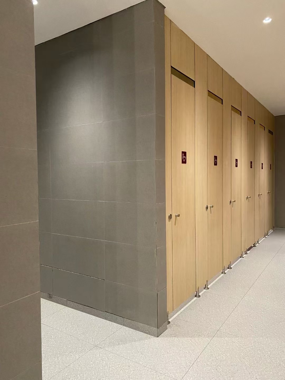 Fully enclosed HPL toilet cubicle for shopping malls in a modern, high-traffic restroom setting.