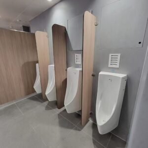 Wood grain color urinal cubicle in a modern commercial restroom setting.