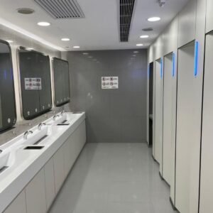 White HPL toilet cubicle for commercial spaces with LED lighting in a modern, high-traffic restroom setting.